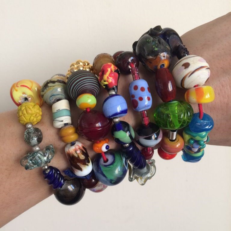 Community building: Instructor Amy Lemaire shows off four years of Bead Exchange Bracelets. Each bead was made by a different Bead Project Artist.