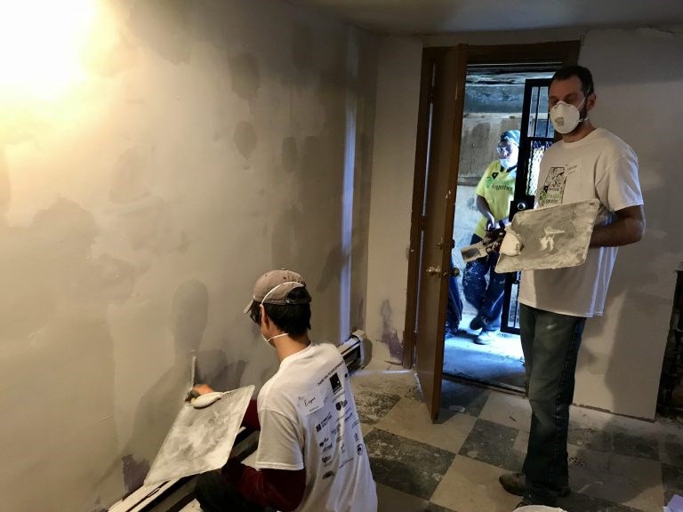 Volunteers fixing the basement walls of Mrs. Moore's house.