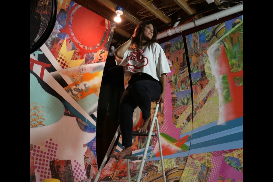 Bianca works on a ladder while installing her &#8220;Around the World&#8221; mural. Photo: B. Romero/ IG