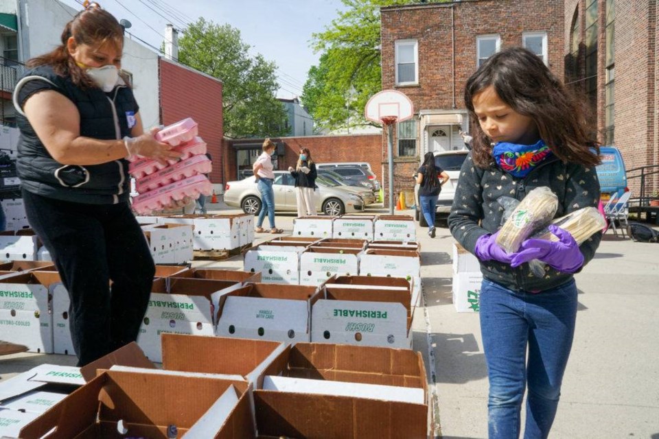 6-year-old Luna Fischer helps the food boxes with tortillas. Photo by Russell Frederick.