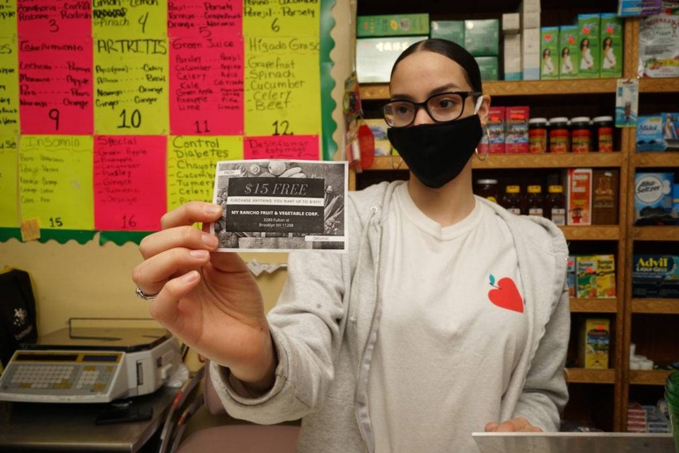Laury Paulino, former CHCCC student, holds one of the homemade vouchers for her parents new grocery store. Photo by Russell Frederick.