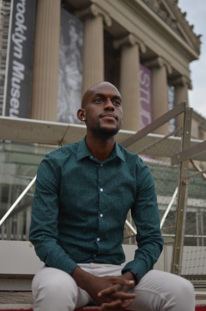 Jamell Henderson sits in front of the Brooklyn Museum