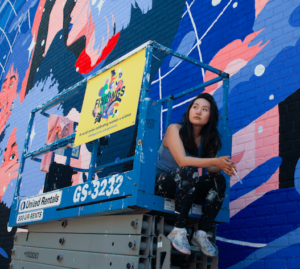 Multidisciplinary artist Amanda Phingbodhipakkiya with her mural. Photo: provided. 