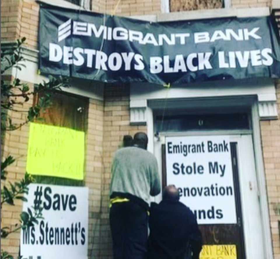 Signs are posted on Victoria Stennett's former home protesting her treatment by Emigrant Bank