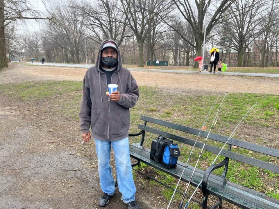 Richard Carnegay stands with his fishing poles in Prospect Park.