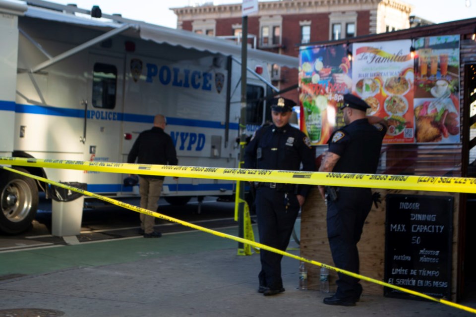 NYPD officers standing behind police tape