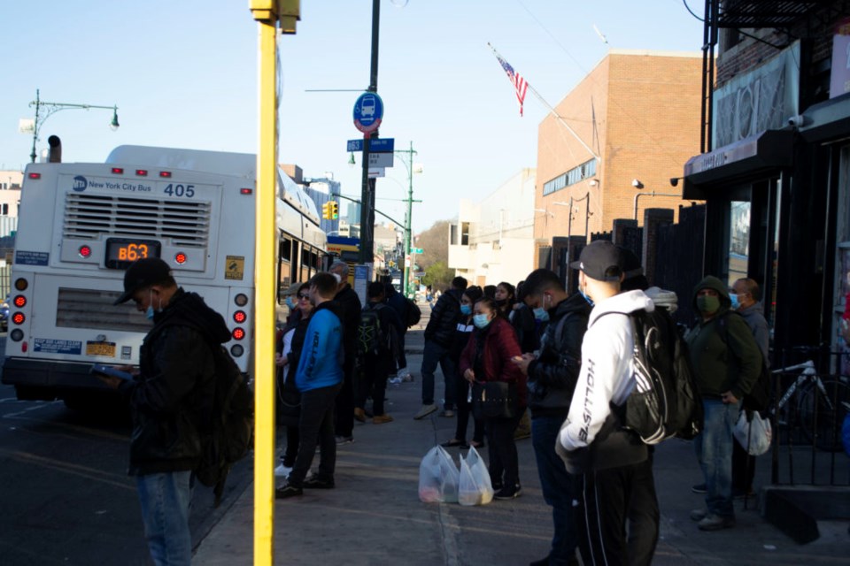 Commuters wait for buses in Sunset Park