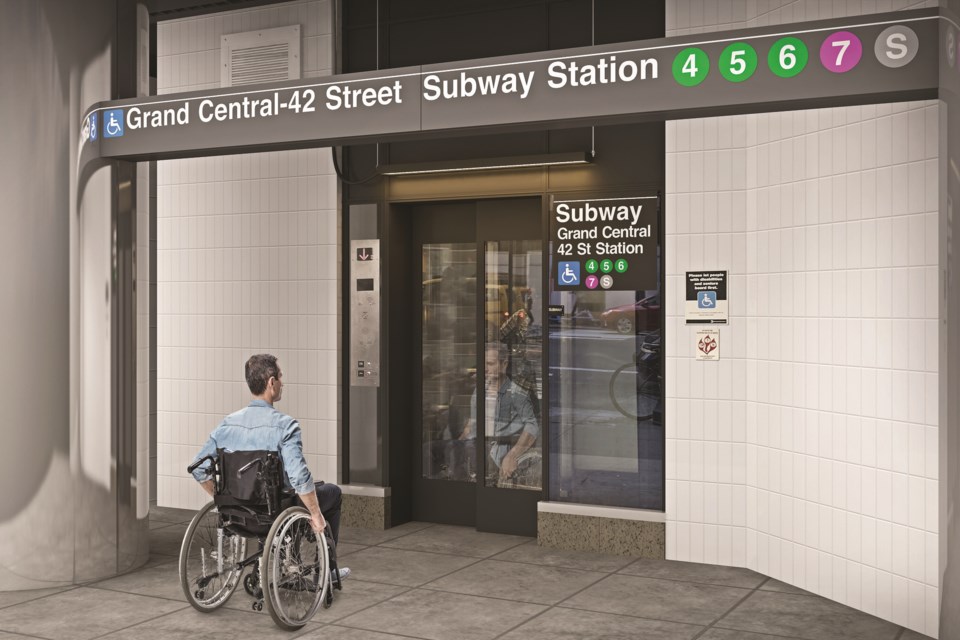 Man in wheelchair waiting for elevator outside Grand Central Subway Station in NYC.