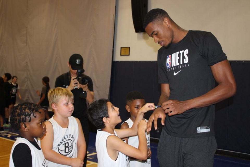 A sweet moment between Nic Claxton and some of the youngest campers. Photo: Miranda Levingston for the BK Reader.