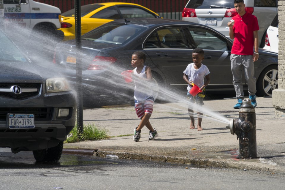 Boys,Play,In,Water,Spray,From,A,Fire,Hydrant,At
