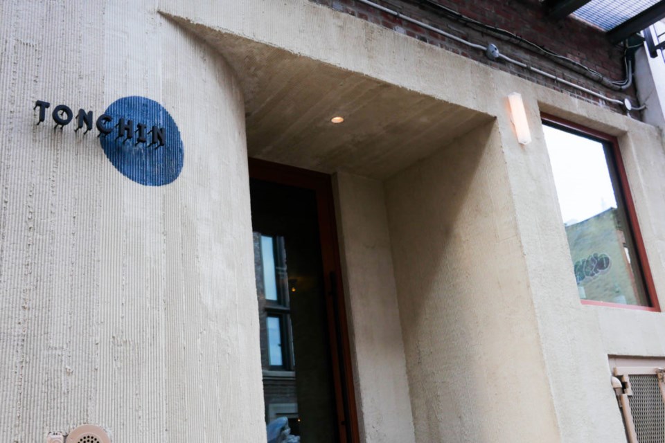 The exterior of Williamsburg restaurant, Tonchin features their logo with a blue spot behind it.