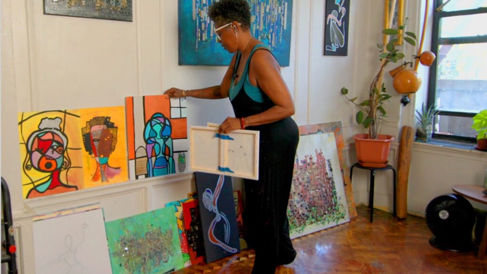Julia Kirtley shows off multiple paintings in her art studio. Photo: Provided/NewYork-Presbyterian.