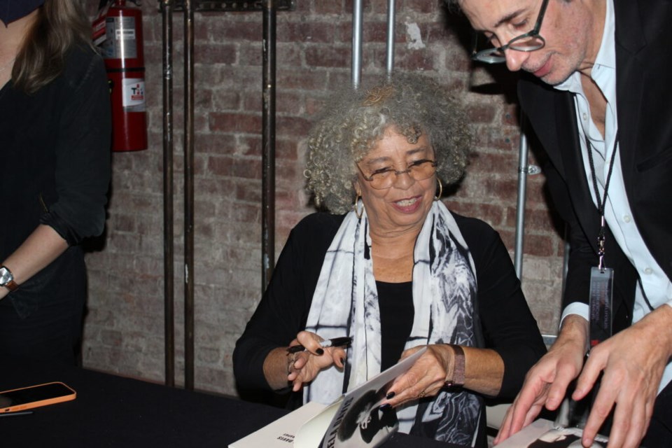 Angela Davis signs her reissued book, "An Autobiography." Photo: Miranda Levingston for BK Reader.