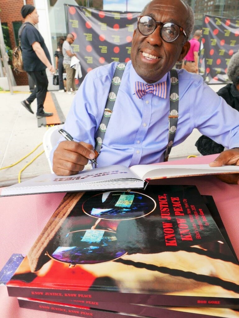 Bob Gore signing copies of "Know Justice, Know Peace."  Photo: Robert Moran.