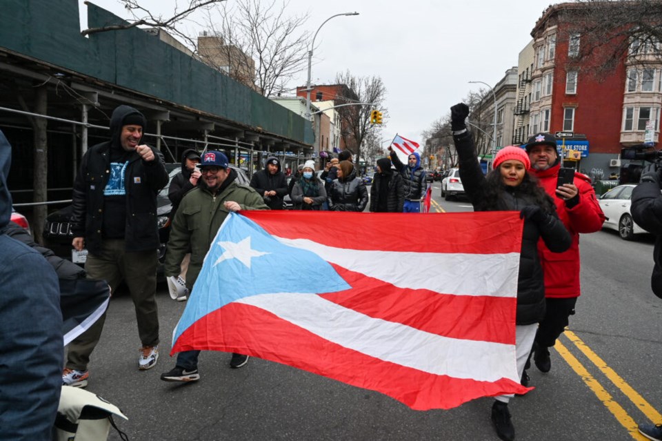 Nicole Torres (r) carries a Puerto Rico flag as Williamsburg residents rally for answers from the DOT Saturday. Photo: Jessy Edwards for the BK Reader.