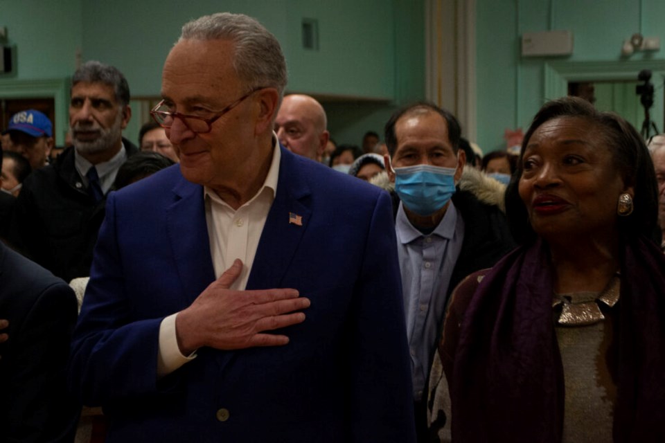 Chuck Schumer is pictured with his hand over his heart next to New York State Sen. Andrea Stewart-Cousins