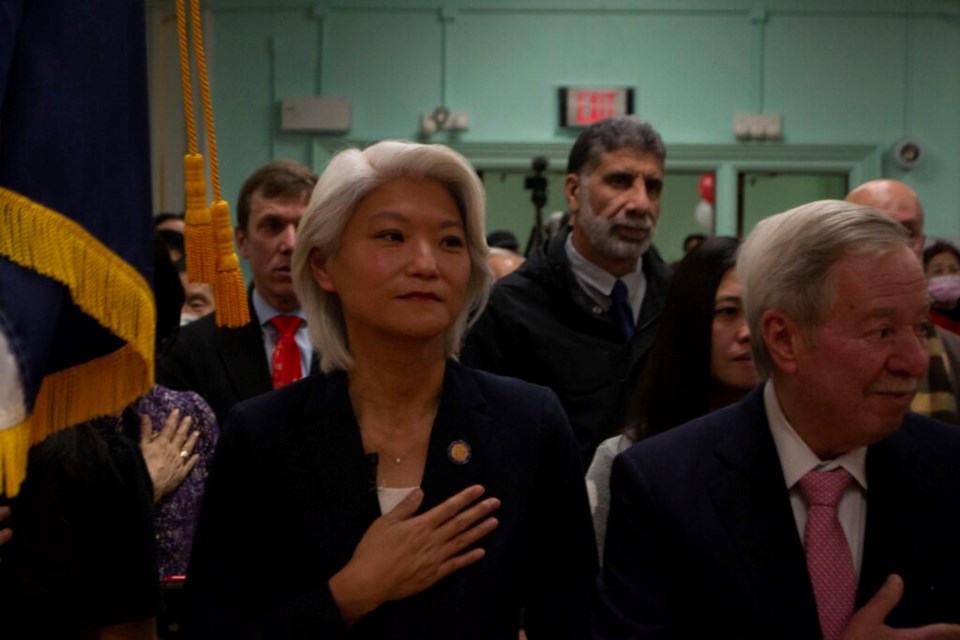 State Senator Iwen Chu is pictured with her hand over hear heart for the pledge of allegience, along with Assemblymember Peter Abbate