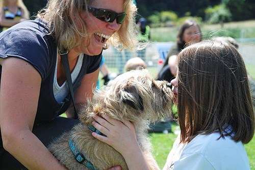 Amanda Ockeloen coaches Buddy as he and Emily give it their best shot in the kissing contest during Dog Days 2015. 