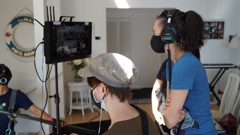 Looking at a screen during filming inside a house