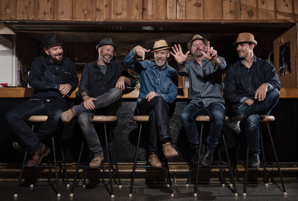 Five men sitting on barstools at the Legion bar and laughing