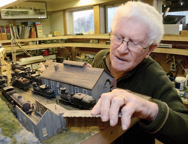 Rob Wynen clipped this photo out of the North Shore News back in 2014, with the intention of calling up Bob Booth. The original caption: "North Vancouver model railroad enthusiast inspects one of the buildings in his train station."