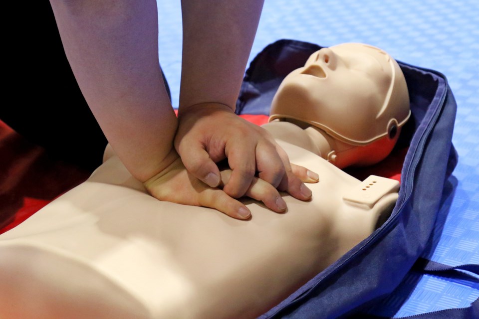 forearms and hands of someone doing CPR on dummy