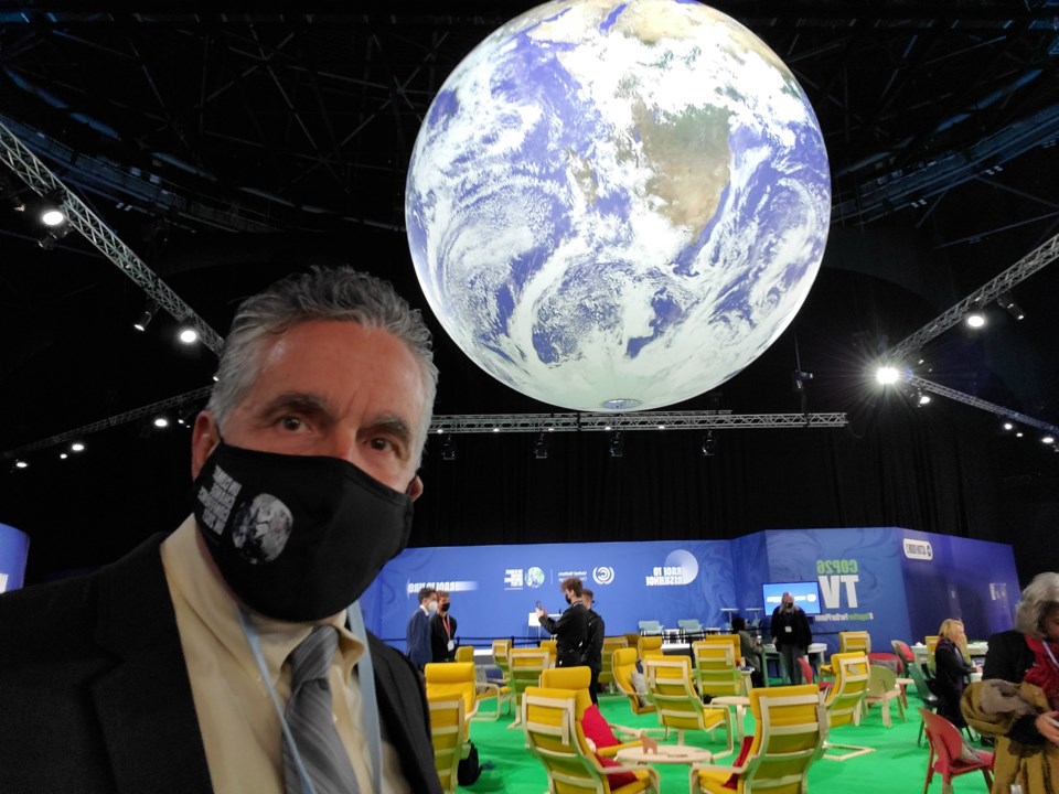 Charles McNeill in front of globe COP26