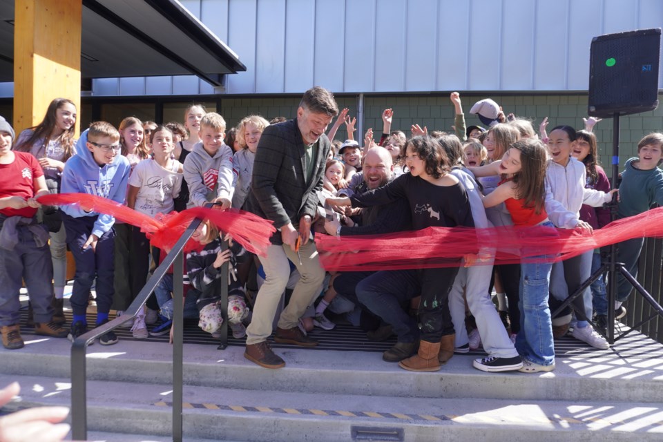 Hearth board chair James Nesbitt and mayor Andrew Leonard, with assistance from a crowd of enthusiastic Bowen Island Community School students, cut the ribbon as part of opening ceremonies at the new Bowen Island Community Centre.