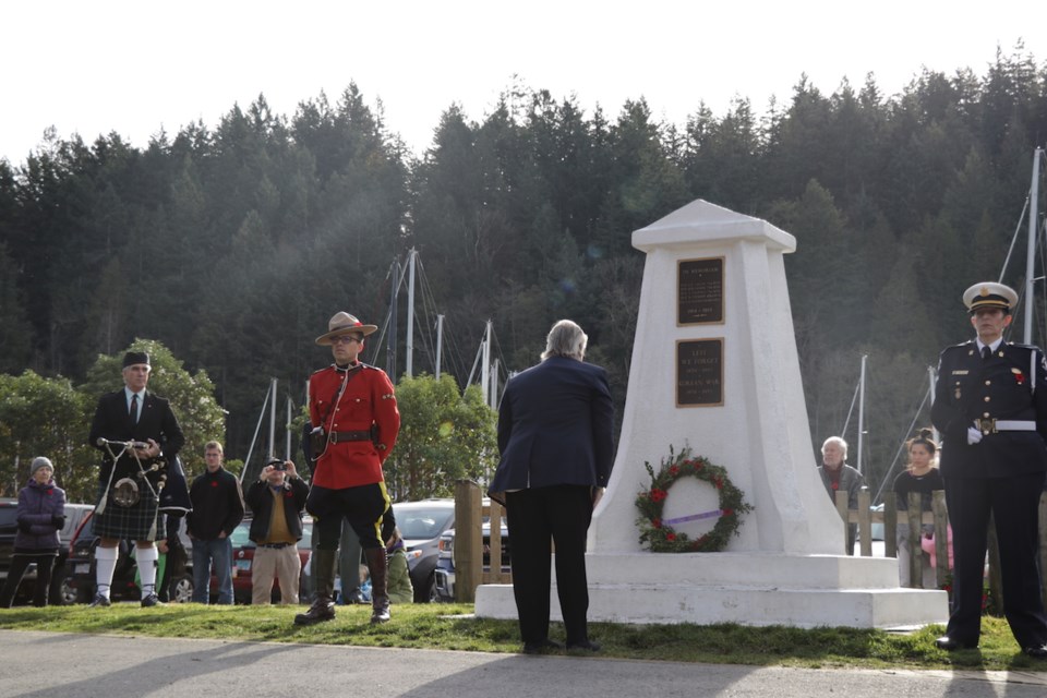 Cpl. Paulo Arreaga and  B.C. Ambulance Service Provincial Honour Guard Janis Treleavan stand on either side of the cenotaph Remembrance Day 2018