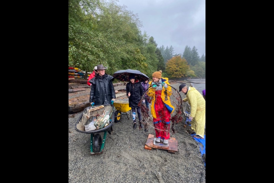 From the bottom of the ocean: Despite pouring rain, volunteers showed up in force for the Oct. 16 Dive Against Debris in Mannion (Deep) Bay. Participants helping collect the debris brought ashore by divers included Bruce Russell (far left), organizer Amber Spitkovski (in bright yellow) and Barry Pynn (far right).