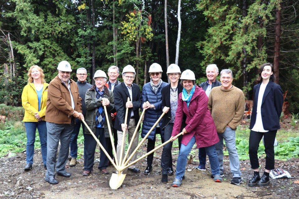 The health centre broke ground Tuesday morning with a land blessing and ceremonial shovel photo. Board members and a couple of major donors got in on the six-handled shovel (courtesy of Bruce Russell). Back row: Sheree Johnson, Paul Welsh, Brian Thomas-Peter, Dr. Clive Jones, Paul Stratford, Maija Tiesmaki;  Front row: Navroz Bandali, Bill Brown, Tim Rhodes, Kathy Bellringer, Colleen O’Neil, Dr. Susanne Schloegl. Board members not pictured include Maria Turnbull, Greg Shepherd, Gordon Orlikow, Sandra Guarasc, Jennifer McGowan and Dr. Lloyd Purdy.