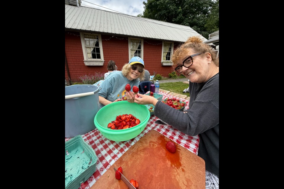 Jane Miller( left) and Gillian Smith prepare strawberries for delicious Strawberry Shortcake.