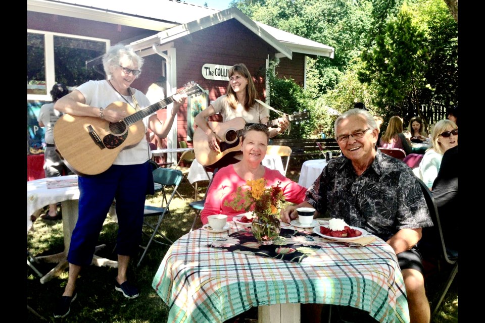 Lorraine Ashdown and Lois Belluk (guitars) serenade Anna-Marie and Murray Atherton under the shade of the now-departed Apple Tree.