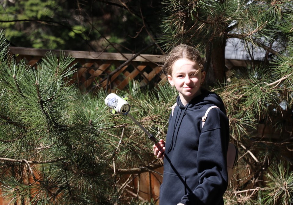 Hadley Shannon holding up a beer can with a trash picker