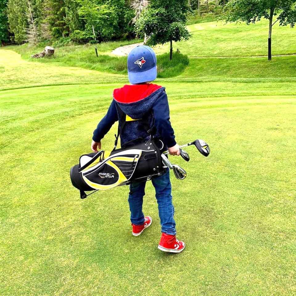 Kid with golf clubs