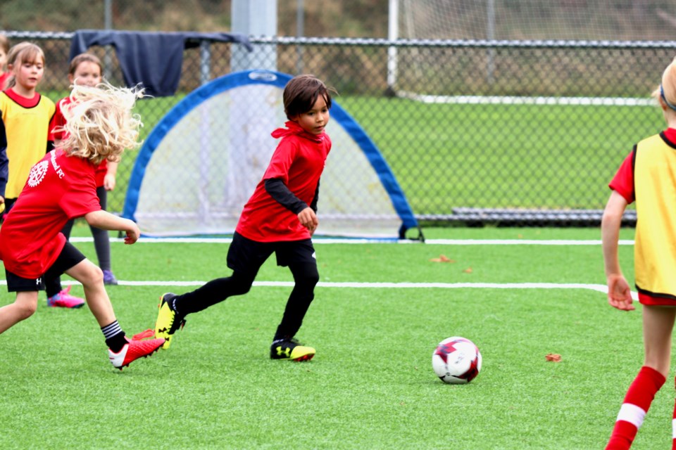 Kids running after a soccer ball