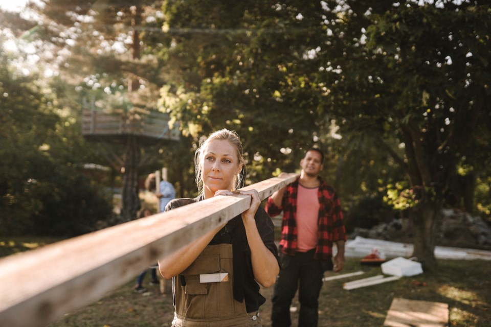 A couple carrying a piece of wood