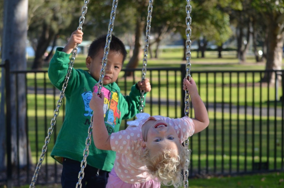 Two kids on swings on playground