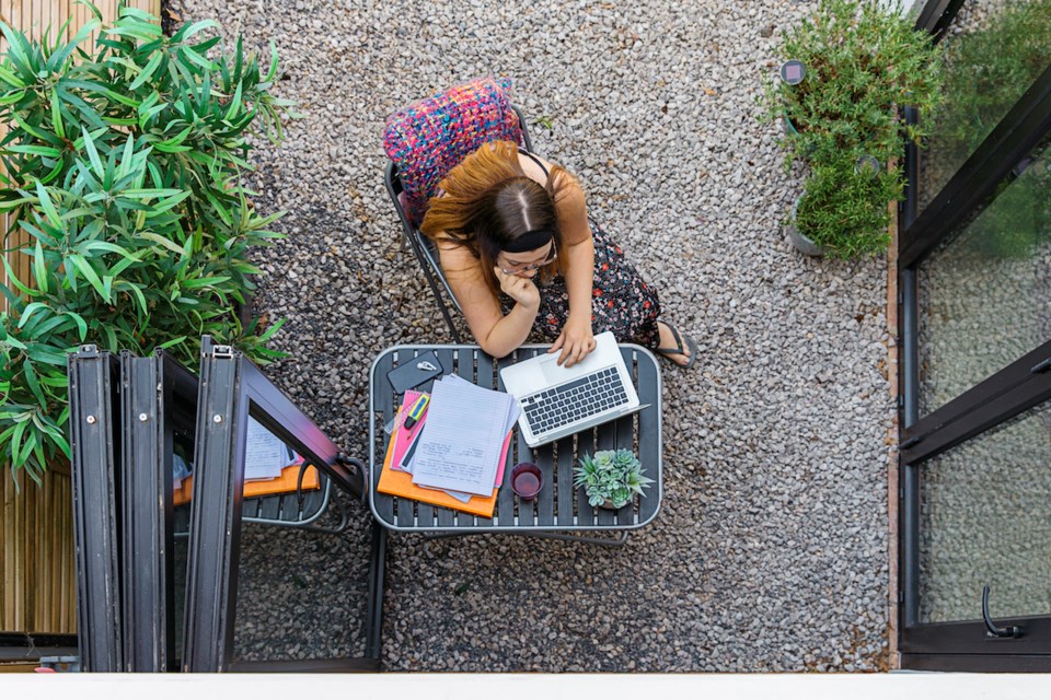 Student working at a table in a garden