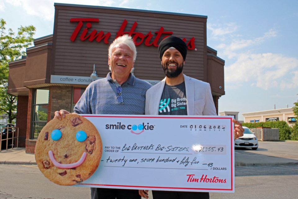 Local Tim Hortons owner Perry Thornton presented a cheque for $21,755.43 to Big Brothers Big Sisters of Peel York's director of development, Panveer Lachhar, at the Tim Hortons at 440 Holland St. W. on Thursday.