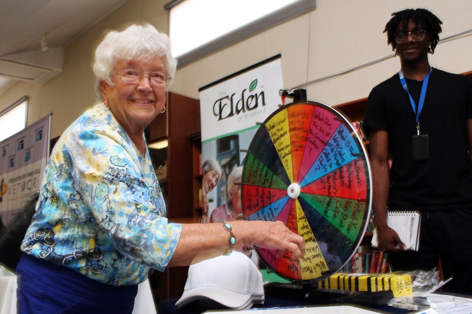 Olga Bishop spins a trivia wheel with the help of Jayden Scobie-Jeffers at the BWG Leisure Centre table, during the Seniors Health and Wellness Fair, at the Danube Seniors Leisure Centre at 715 Simcoe Rd. in Bradford, on Thursday.