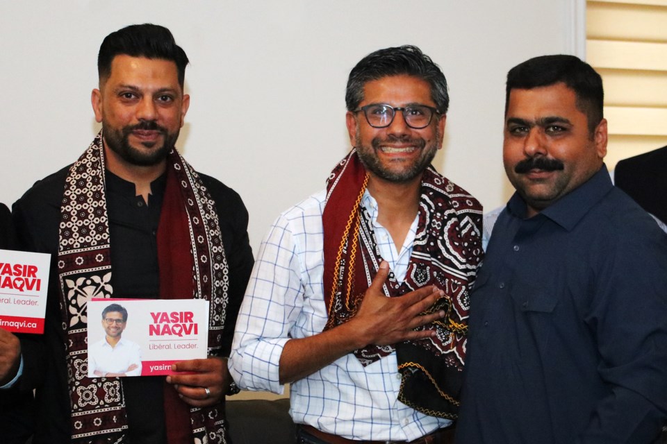 From left: Furqan Abbassi stands with Ontario Liberal Party leader candidate Yasir Naqvi after he was presented with a traditional scarf by Fareed Abro during an Eid Milan party hosted by Abro at his home in Bradford on Saturday July 8, 2023.