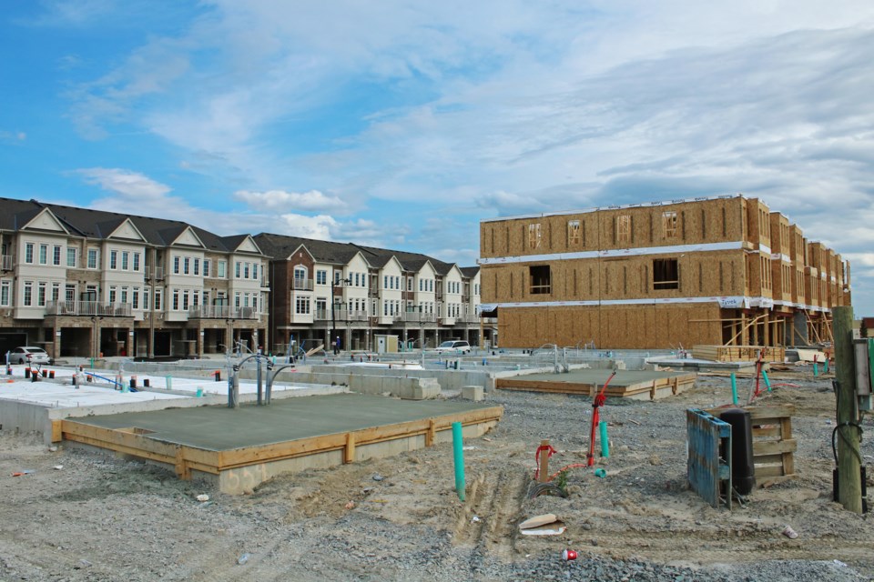 Recently poured foundations and porches can be seen in front of partially constructed townhouses on Paisley Drive, with near finished units in the background along Mel Irving Drive in Bradford on Tuesday, Aug. 1, 2023.