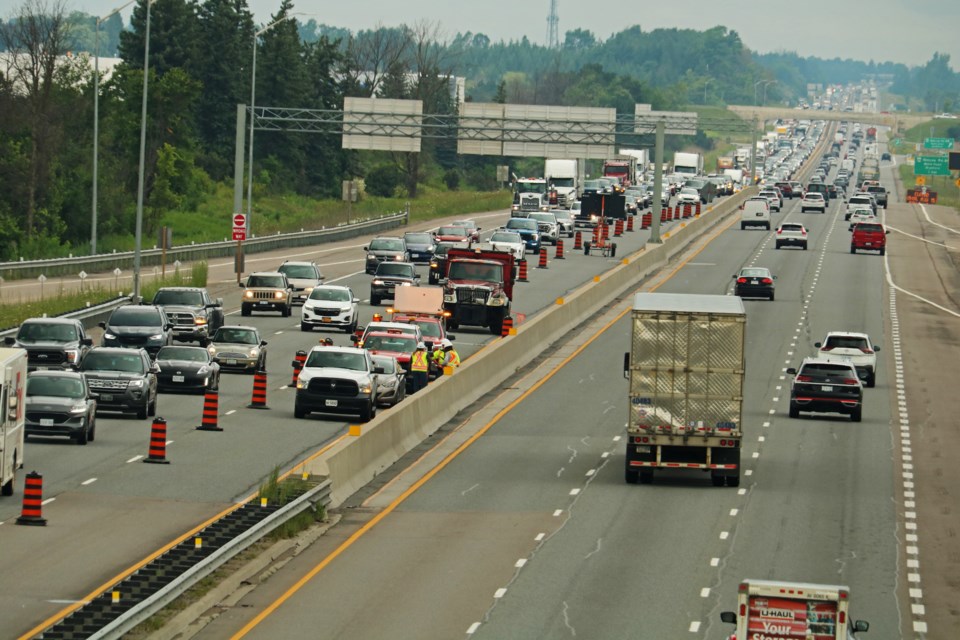 Looking north from the bridge over Line 5, southbound traffic can be seen backed up on Highway 400 on Tuesday, Aug. 8, 2023, as crews had closed the left lane to investigate a sinkhole that opened Monday evening.