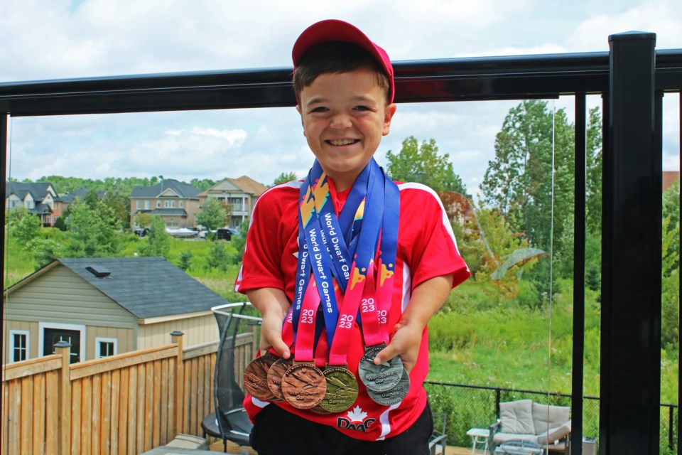 Christian Tabone, 12, wears the eight medals he won while competing in the World Dwarf Games in Cologne Germany from July 28 to Aug. 5 2023.