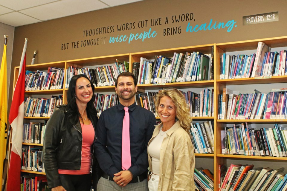 From left: Lisa Artuso, parent council member; Michael Borgia, principal; and Josie Patera, parent council member are seen in the student resource centre at Holy Trinity Catholic Secondary School in Bradford on Monday, Sept. 18, 2023, where the Spread the Love Project saw positive quotes installed on the walls.
