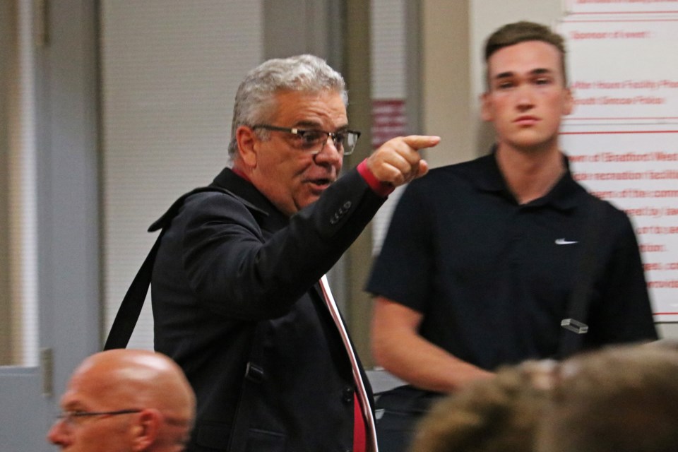 Mayor James Leduc addresses a member of the crowd as he leaves council chambers Tuesday night, cutting the meeting short.