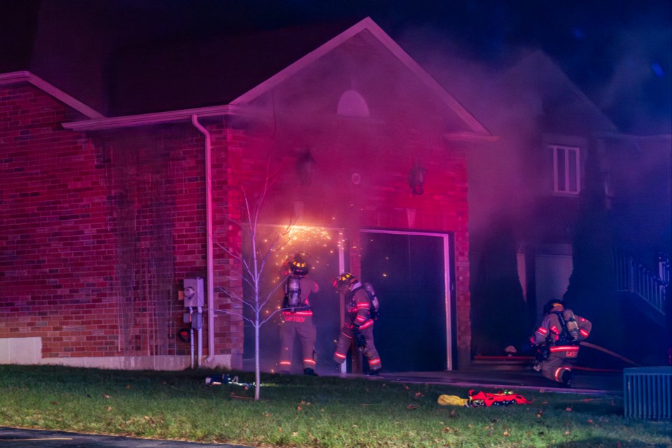 Firefighters cut through the garage door to gain access to the fire. | Paul Novosad for Bradford Today