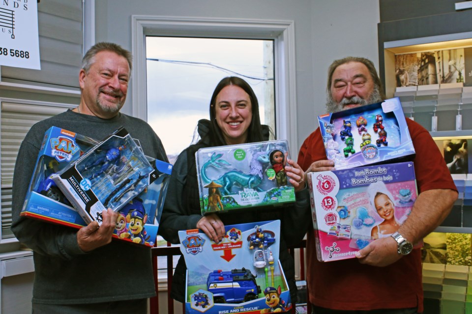 From left: Lawrence Hellings, Jade Fisher (Lawrence’s daughter) and Jeff Hellings hold some of the toys that have been donated so far to the annual toy drive at Decorator’s Edge at 284 Holland St. W. in Bradford.