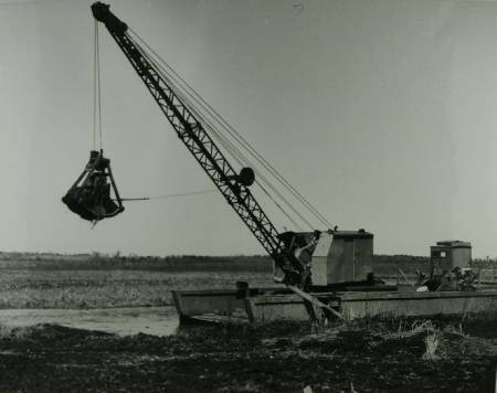 A clam digger mounted on a barge, cleaning the river to improve drainage in the Holland Marsh.